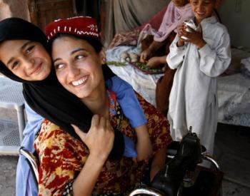 young girl hugs a woman in a wheelchair