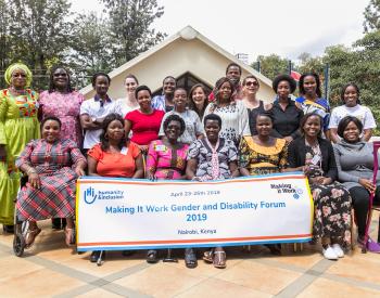 Group photo of the participants to the MIW third Gender and Disbality, front row participants are holding a banner of the event